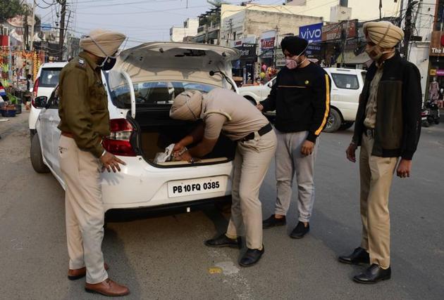 Cops checking vehicles at Ghumar Mandi in Ludhiana on Friday.(Harsimar Pal Singh/HT)