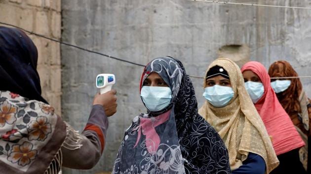 Women wear protective masks as they get their temperature checked as the spread of the coronavirus disease (Covid-19) continues, in Karachi, Pakistan.(Reuters) Women wear protective masks as they get their temperature checked as the spread of the coronavirus disease (Covid-19) continues, in Karachi, Pakistan.(Reuters)
