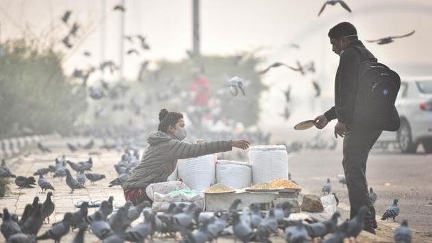Pigeons gather as a man buys bird feed on a smoggy day at Burari in New Delhi on November 15. There has been a continuous decline in average daily new cases for the past five weeks; from around 73,000 new Covid-19 cases being reported in the beginning of October to the current figure of around 49,000, the ministry shared on Twitter. (Sanchit Khanna / HT Photo) Pigeons gather as a man buys bird feed on a smoggy day at Burari in New Delhi on November 15. There has been a continuous decline in average daily new cases for the past five weeks; from around 73,000 new Covid-19 cases being reported in the beginning of October to the current figure of around 49,000, the ministry shared on Twitter. (Sanchit Khanna / HT Photo)