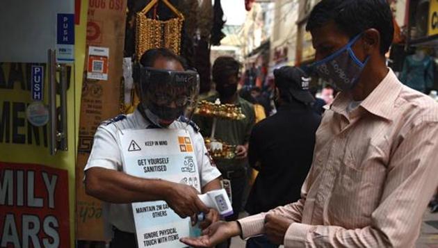 A security guard checks the body temperature of a customer outside a shop in a market amid the Covid-19 pandemic in New Delhi. (AFP PHOTO.) A security guard checks the body temperature of a customer outside a shop in a market amid the Covid-19 pandemic in New Delhi. (AFP PHOTO.)