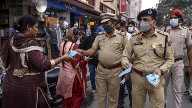Police personnel distribute face masks to people on the streets in Amritsar on November 12. India has reported less than 50,000 new coronavirus disease (Covid-19) cases for eight days in a row as on November 16, as the total number of cases in the country approaches nine million, according to data released by the Union Ministry of Health and Family Welfare. (Narinder Nanu / AFP)