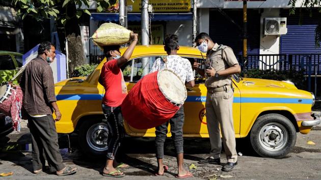 A policeman helps traditional drummers, who had travelled from villages, hire a taxi to be dropped at a worship venue for a performance, in Kolkata on November 14. On the twin occasions of Diwali and Kali Puja celebrations across several states, many temples across the country streamed prayer sessions online to avoid large gatherings. (Bikas Das / AP) A policeman helps traditional drummers, who had travelled from villages, hire a taxi to be dropped at a worship venue for a performance, in Kolkata on November 14. On the twin occasions of Diwali and Kali Puja celebrations across several states, many temples across the country streamed prayer sessions online to avoid large gatherings. (Bikas Das / AP)