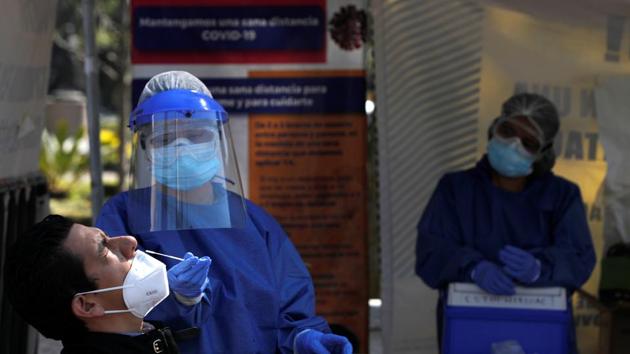 A healthcare worker wearing personal protective equipment (PPE) takes a swab sample from a man to be tested for the coronavirus disease (Covid-19) in Mexico City, Mexico.(Reuters) A healthcare worker wearing personal protective equipment (PPE) takes a swab sample from a man to be tested for the coronavirus disease (Covid-19) in Mexico City, Mexico.(Reuters)