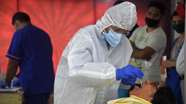 A junior medical doctor takes a swab sample from a Vashi resident on Wednesday.(HT PHOTO)