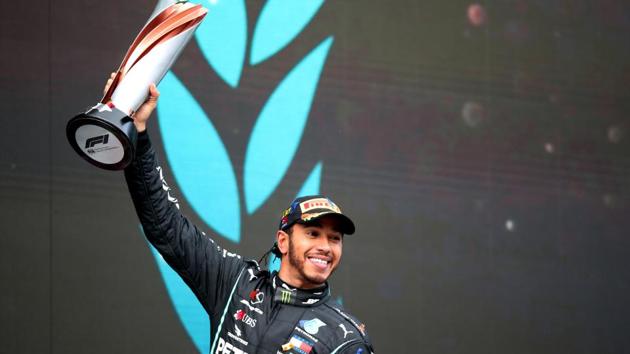 Formula One F1 - Turkish Grand Prix - Istanbul Park, Istanbul, Turkey - November 15, 2020 Mercedes' Lewis Hamilton celebrates on the podium with a trophy after winning the race and the world championship Pool via REUTERS/Tolga Bozoglu(Pool via REUTERS)