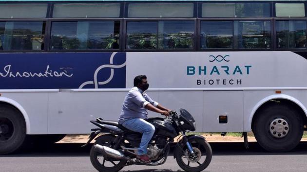 A man rides his motorcycle past a parked bus of Indian biotechnology company Bharat Biotech outside its office in Hyderabad.(REUTERS) A man rides his motorcycle past a parked bus of Indian biotechnology company Bharat Biotech outside its office in Hyderabad.(REUTERS)