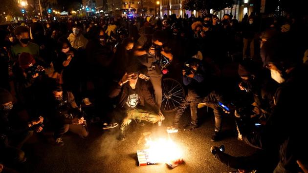 Protesters set fire to a Make America Great Again (MAGA) hat and a poster depicting US President Donald Trump in Washington on November 14. Trump seemed to be following the evening’s events, taking to Twitter to accuse the city’s mayor of “not doing her job” and calling on the police to “get going - do your job and don’t hold back,” AFP reported. (Erin Scott / REUTERS) Protesters set fire to a Make America Great Again (MAGA) hat and a poster depicting US President Donald Trump in Washington on November 14. Trump seemed to be following the evening’s events, taking to Twitter to accuse the city’s mayor of “not doing her job” and calling on the police to “get going - do your job and don’t hold back,” AFP reported. (Erin Scott / REUTERS)