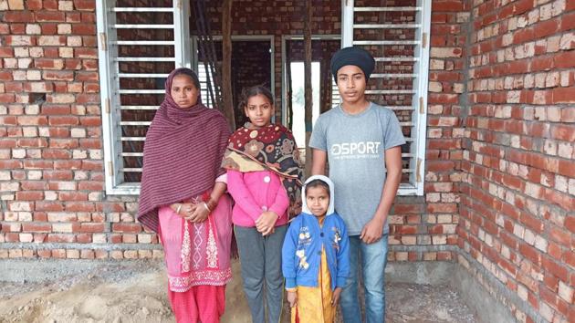Victim Jagmail Singh’s wife Manjit Kaur along with her three children at her under construction house at Dhandiwal village of Sangrur.(HT Photo)