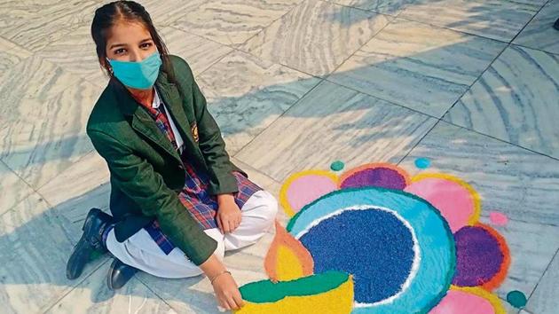 A student of Green Land Senior Secondary Public School, Ludhiana, showing her rangoli on the occasion.(HT)