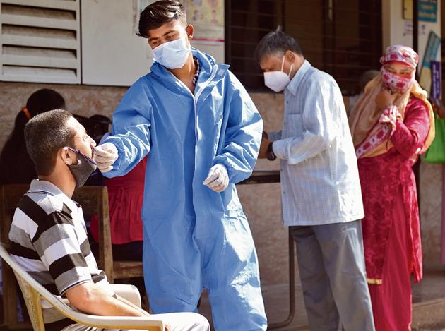 A health worker takes a swab sample of a resident in Mankhurd on Tuesday.(Satish Bate/HT Photo)