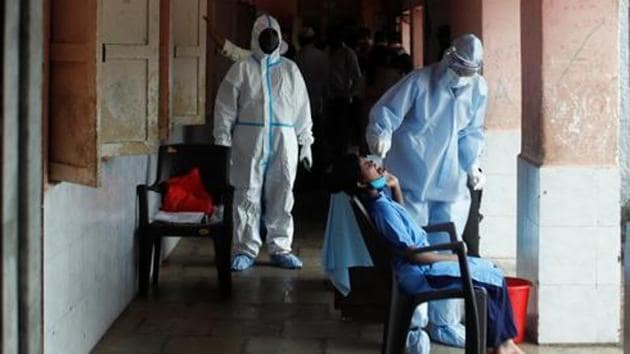 A health worker in personal protective equipment (PPE) collects a swab sample of a child at a children's home during a check up campaign for the coronavirus disease (Covid-19) in Mumbai.(Reuters) A health worker in personal protective equipment (PPE) collects a swab sample of a child at a children's home during a check up campaign for the coronavirus disease (Covid-19) in Mumbai.(Reuters)