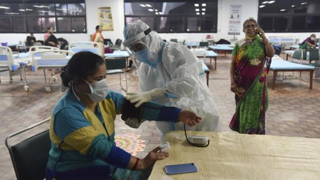A health worker examines the blood pressure of a patient at the Commonwealth Games (CWG) Village Covid-19 Care Centre in New Delhi on November 15. Meanwhile, the central government has formed multidisciplinary teams to visit all private hospitals in Delhi to check the status of compliance of various directions issued by the Union Health Ministry for testing and treating Covid-19 patients. (Sanjeev Verma / HT Photo) A health worker examines the blood pressure of a patient at the Commonwealth Games (CWG) Village Covid-19 Care Centre in New Delhi on November 15. Meanwhile, the central government has formed multidisciplinary teams to visit all private hospitals in Delhi to check the status of compliance of various directions issued by the Union Health Ministry for testing and treating Covid-19 patients. (Sanjeev Verma / HT Photo)