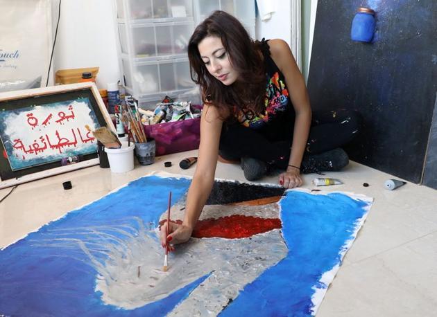Lebanese artist, Hayat Nazer, paints as she attends an interview with Reuters in Beirut, Lebanon November 10, 2020. (REUTERS)