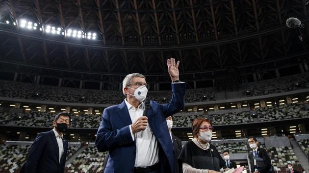 IOC President Thomas Bach wearing a face mask waves as he speaks to the media at the National Stadium, the main venue for the 2020 Olympic and Paralympic Games postponed until July 2021 due to the coronavirus pandemic, in Tokyo Tuesday, Nov. 17, 2020. Bach said during this week's trip to Tokyo that he is “encouraging” all Olympic “participants” and fans to be vaccinated - if one becomes available - if they are going to attend next year's Tokyo Olympics. (Behrouz Mehri/Pool Photo via AP)(AP)