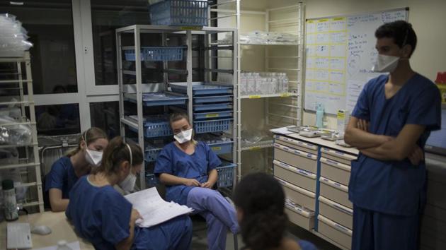 At the end of her shift, 26-year-old Nurse Pauline Reynier, center left, updates the night shift nurses on the statuses of Covid-19 patients in a makeshift ICU at the La Timone hospital in Marseille, southern France.(AP) At the end of her shift, 26-year-old Nurse Pauline Reynier, center left, updates the night shift nurses on the statuses of Covid-19 patients in a makeshift ICU at the La Timone hospital in Marseille, southern France.(AP)