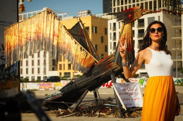Lebanese artist, Hayat Nazer, stands in front of a Phoenix-inspired artwork she created. (Instagram)