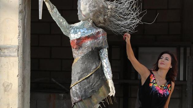 Lebanese artist, Hayat Nazer, poses near her statue made entirely out of broken glass and debris of the August 4 port explosion, during an interview with Reuters in Beirut, Lebanon November 10, 2020.(REUTERS) Lebanese artist, Hayat Nazer, poses near her statue made entirely out of broken glass and debris of the August 4 port explosion, during an interview with Reuters in Beirut, Lebanon November 10, 2020.(REUTERS)