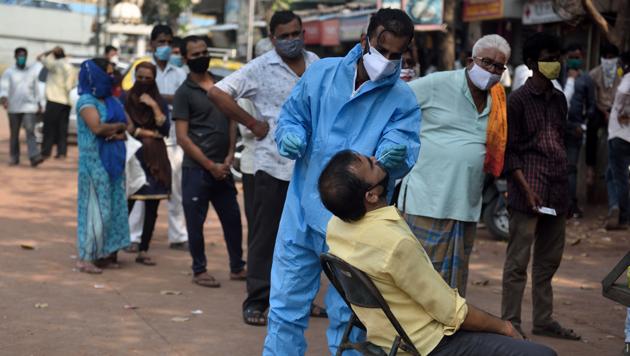 A health worker collects a swab sample of a resident in Mankhurd on Thursday. (Satish Bate/HT Photo) A health worker collects a swab sample of a resident in Mankhurd on Thursday. (Satish Bate/HT Photo)
