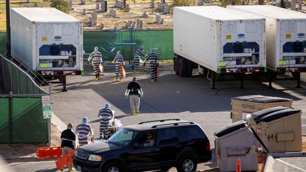El Paso County detention inmates help move bodies to refrigerated trailers outside the Medical Examiner's Office which is located next to a cemetery in El Paso on November 16. In the border city of El Paso, overwhelmed morgues have begun paying jail inmates $2 an hour to help transport the bodies of Covid-19 victims. (Ivan Pierre Aguirre / REUTERS) El Paso County detention inmates help move bodies to refrigerated trailers outside the Medical Examiner's Office which is located next to a cemetery in El Paso on November 16. In the border city of El Paso, overwhelmed morgues have begun paying jail inmates $2 an hour to help transport the bodies of Covid-19 victims. (Ivan Pierre Aguirre / REUTERS)