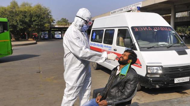 A passengers giving his sample for Covid testing at the Sector-17 ISBT in Chandigarh on Thursday.(Keshav Singh/HT)