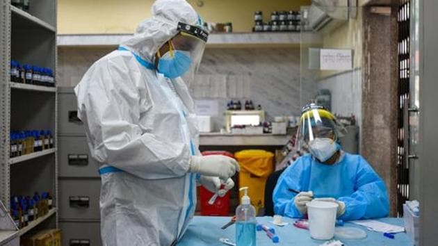 Medics work with swab samples collected for coronavirus tests, in Defence Colony, New Delhi, India, on Monday, November 16, 2020.(Amal KS/HT PHOTO)