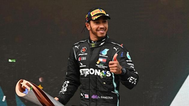 FILE PHOTO: Formula One F1 - Turkish Grand Prix - Istanbul Park, Istanbul, Turkey - November 15, 2020 Mercedes' Lewis Hamilton celebrates on the podium with a trophy after winning the race and the world championship Pool via REUTERS/Ozan Kose/File Photo(Pool via REUTERS)