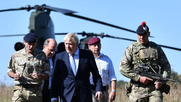 In this file photo taken on September 19, 2019, Britain's Prime Minister Boris Johnson (C) arrives with Britain's Defence Secretary Ben Wallace (2L) to visit military personnel in Salisbury, southwest England.(AFP/ FILE)