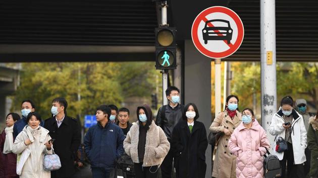 People walk along a street in Beijing on November 19.(AFP) People walk along a street in Beijing on November 19.(AFP)