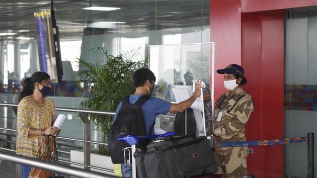 Travellers show their IDs while maintaining social distancing at an entry gate at Terminal T2 of Indira Gandhi International (IGI) Airport .(Vipin Kumar/HT PHOTO)