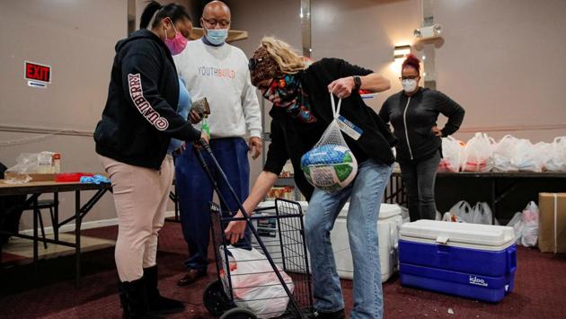 Volunteers hand out Thanksgiving turkeys and bags of free holiday food to those in need at the Central Family Life Centre in Staten Island on November 19. The surge in US cases has sufficiently alarmed authorities that they asked Americans to stay home for next week’s Thanksgiving holiday, which normally sees millions travel to gather with their families for meals, AFP reported. (Brendan McDermid / Reuters) Volunteers hand out Thanksgiving turkeys and bags of free holiday food to those in need at the Central Family Life Centre in Staten Island on November 19. The surge in US cases has sufficiently alarmed authorities that they asked Americans to stay home for next week’s Thanksgiving holiday, which normally sees millions travel to gather with their families for meals, AFP reported. (Brendan McDermid / Reuters)