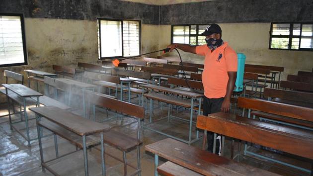A municipal worker sanitizes a classroom of a school ahead of its reopening