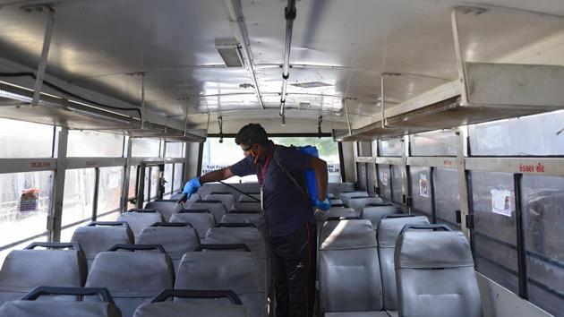 A man sanitizes a bus after a curfew was imposed to arrest a coronavirus surge, in Ahmedabad on November 21. In response to outbreaks, local authorities are re-introducing restrictions on movements like in Gujarat or implementing other checks like random screenings between Uttar Pradesh and Delhi. The Centre is also considering rushing expert teams to assist local administrations in disease management where needed. (Sam Panthaky / AFP)