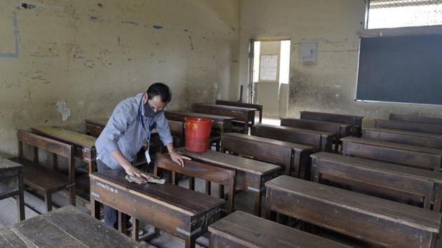 A school staffer cleans a classroom at Bal Vikas Vidya Mandir, Jogeshwari (East), on Thursday as schools were directed to reopen from November 23. The civic body on Friday declared that the schools will remain closed till December 31.(Satyabrata Tripathy/HT Photo)