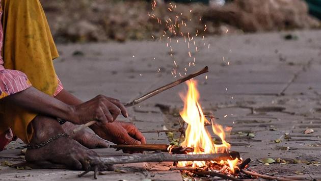 A woman lights a fire to warm herself on a cold day in New Delhi on November 21. Delhi on November 22 recorded a minimum temperature of 6.9 degrees Celsius, breaking the previous November record of 7.3 degrees Celsius witnessed in 2006, HT reported citing India Meteorological Department (IMD) recordings. (ANI)
