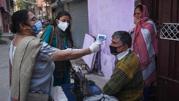 District administration personnel thermal screening people during door to door Covid-19 surveys at Raghubir Nagar in New Delhi.(Sanchit Khanna/HT PHOTO)