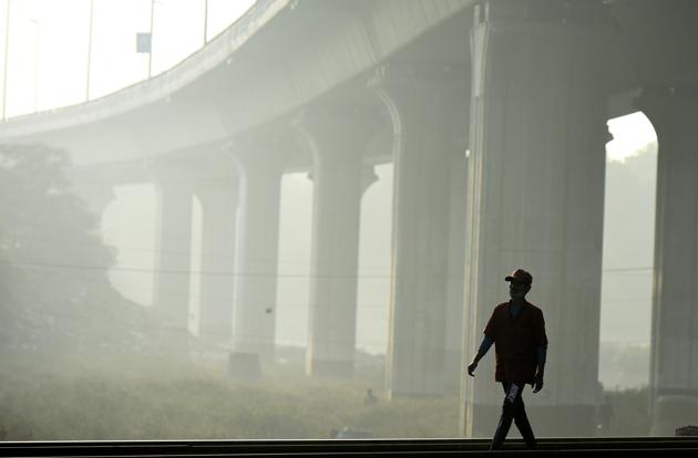 A boy walks along a railway track amid hazy weather conditions at Nizamuddin in New Delhi on November 20.(Biplov Bhuyan/HT PHOTO)