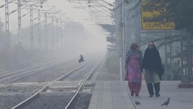 Women wearing warm clothes walk along the platform at Mohamadpur Railway Station near Dwarka in New Delhi on November 22. A cold wave is likely to prevail in isolated pockets of northwest India between November 20 and 26. A cold wave is declared when minimum temperature is under 10 degrees Celsius and the departure from normal is 4.5 degrees Celsius for more than a day, HT reported. (Vipin Kumar / HT Photo)
