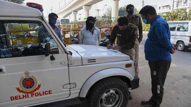 A policeman fines a commuter for not maintaining social distancing as a preventive measure against coronavirus infection in New Delhi on November 22. Meanwhile, the penalty for not wearing a mask in public has also been increased from ₹ 500 to ₹ 2000 in the light of a worsening third-wave of coronavirus infections. (Prakash Singh / AFP) A policeman fines a commuter for not maintaining social distancing as a preventive measure against coronavirus infection in New Delhi on November 22. Meanwhile, the penalty for not wearing a mask in public has also been increased from ₹ 500 to ₹ 2000 in the light of a worsening third-wave of coronavirus infections. (Prakash Singh / AFP)