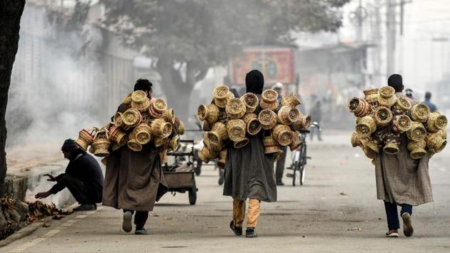 Hawkers carry Kangri (earthen pots covered with wicker) on a cold day in Srinagar on November 19. According to Kuldeep Shrivastava, due to back-to-back western disturbances, the weather department expects snowfall in the hills to continue - which means that minimum temperatures will gradually fall further after the next western disturbance passes. (Tauseef Mustafa / AFP)