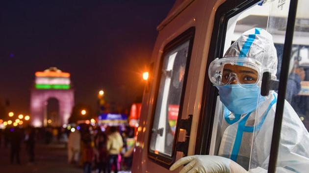 A health worker waits to collect samples for Covid-19 testing from a mobile van, organised by NDMC, at Rajpath in New Delhi, Sunday.(PTI Photo)