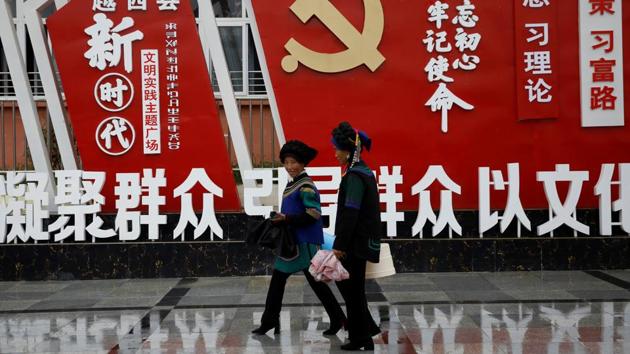 Ethnic Yi women walk past an installation featuring a logo of Communist Party of China at the Chengbei Ganen Community, a residential complex built for a relocation programme as part of China's poverty alleviation effort, in Yuexi county.(Reuters file) Ethnic Yi women walk past an installation featuring a logo of Communist Party of China at the Chengbei Ganen Community, a residential complex built for a relocation programme as part of China's poverty alleviation effort, in Yuexi county.(Reuters file)