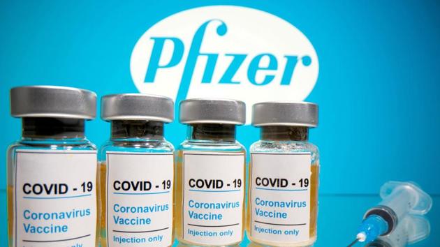 Vials with a sticker reading, "Covid-19 / Coronavirus vaccine / Injection only" and a medical syringe are seen in front of a displayed Pfizer logo in this illustration taken October 31.(Reuters file)
