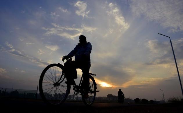 A cyclist on his way under a partially cloudy sky on the PAU campus in Ludhiana on Monday. (Gurpreet Singh/HT)