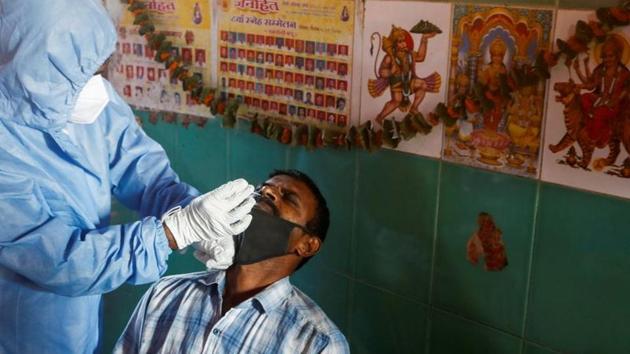 A health worker in personal protective equipment (PPE) collects a swab sample from a man during a rapid antigen testing campaign for the coronavirus disease (Covid-19) at a vegetable market in Mumbai.(Reuters) A health worker in personal protective equipment (PPE) collects a swab sample from a man during a rapid antigen testing campaign for the coronavirus disease (Covid-19) at a vegetable market in Mumbai.(Reuters)