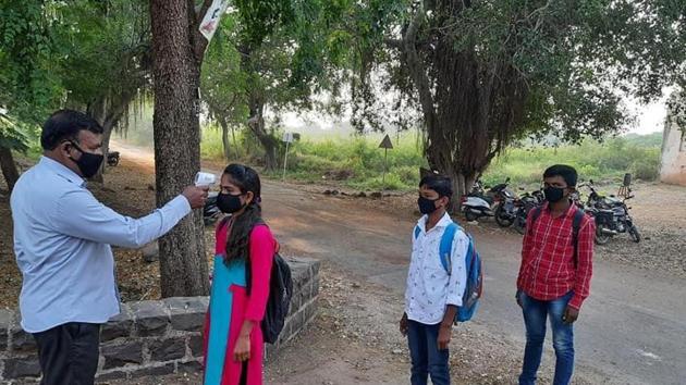 A staff member checks the temperature of students at Shankarrao Bajirao Patil High School in Solapur on Monday. A staff member checks the temperature of students at Shankarrao Bajirao Patil High School in Solapur on Monday.