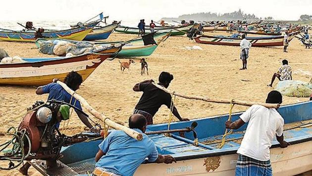 Fishermen move their boats after an alert is sounded over Cyclone Nivar, in Tamil Nadu’s Mamallapuram on Monday.(PTI)