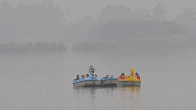 People boating in Sukhna Lake amid a cover of mist in Chandigarh on Tuesday.(Keshav Singh/HT)