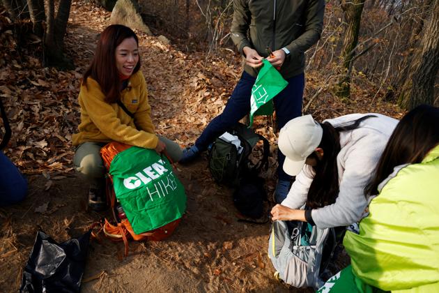 Kim Kang-Eun gets ready with her colleagues to collect litter while hiking a mountain in Incheon, South Korea, November 16, 2020. (REUTERS)