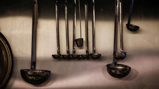 Ladles for cooking ramen noodles are seen hanging in the kitchen of Shirohachi in Tokyo on November 20. There is a growing insecurity among such employees that a resurgent virus could trigger lay-offs and shutdowns that they somehow survived during the first blow of the pandemic. (Issei Kato / Reuters)