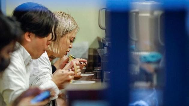 Customers eat ramen inside Shirohachi in Tokyo on November 20. According to Reuters’ report, the pandemic has damaged Japan’s “mom and pop” restaurants and small businesses at such a wipe down rate that even the government’s subsidies will not restore losses in the long run. (Issei Kato / Reuters)